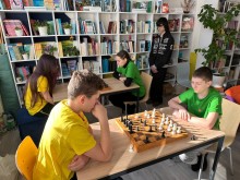 Турнір з шах.
Діти сидять за столом та уважно дивляться на шахи, планують свій хід.