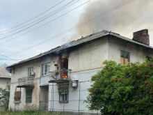 Двоповерхова будівля горить через ворожий обстріл.