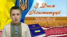 Учасник конкурсу декламує вірш до Дня Конституції України. На фоні - державна символіка та вітальне гасло.