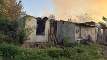 Господарська будівля зі зруйнованим обстрілом дахом.