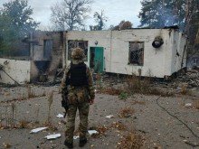 Правоохоронець стоїть біля обгорілого будинку