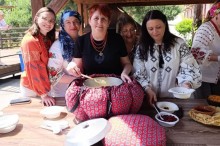 Спеціалісти біля столу на вулиці розливають страву з великого казана, загорнутого в тканинний чохол