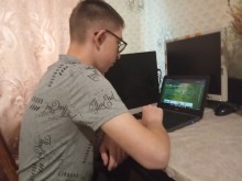 Учень уважно дивиться в екран монітора, на якому показують віртуальну екскурсію по заповідних об'єктах Костянтинівської громади.