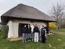 Спільне фото дітей на задньому плані старовинна хатина.