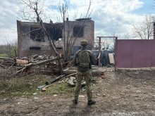 Правоохоронець стоїть біля зруйнованого ворогом будинку