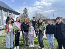 Спільне фото учасників акції.
Хлопці та дівчата тримають у руках саджанці квітів.