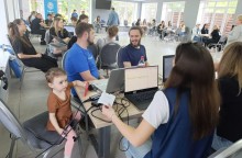 Учасники проєкту за столами в групах спілкуються між собою, серед них - маленька дівчина, наймолодша  учасниця проєкту з Миколаївської громади