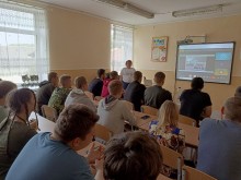 Директорка Краматорського ВПУ виступає перед здобувачами освіти у класі. На екрані - відеоконференція щодо Дня цивільного захисту.
