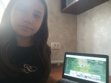 Учениця робить селфі біля монітора ноутбука, на якому дивиться віртуальну екскурсію.