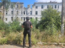 Правоохоронець стоїть біля зруйнованої лікарні у Костянтинівці