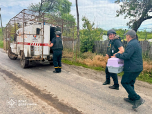Рятувальники групи "Фенікс" саджають людину в евакуаційний автомобіль