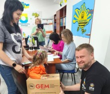 Представник благодійної організації GEM надає гуманітарну допомогу у вигляді продуктового набору переселенці з дитиною у Центрі підтримки ВПО Очеретинської громади у м. Кам’янське