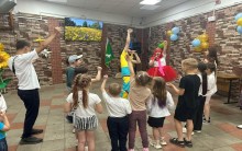 Діти беруть участь у конкурсі, разом із ведучими підіймають одну руку вгору