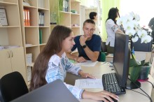 Дівчина у вишиванці сидить за комп'ютером перед церемонією вручення паспортів.