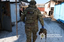 Поліцейський йде по ринку у місті Дружківка. З обох боків понівечені ринкові павільйони. Дія після обстрілу.