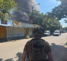 Правоохоронець стоїть біля зруйнованого окупантами магазину