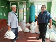 Двоє чоловіків тримають пакети з гуманітарною допомогою