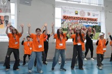 Діти в однакових футболках виконують рухи таночку
