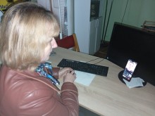 Представник військової адміністрації сидить за столом та слухає доповідача на семінарі