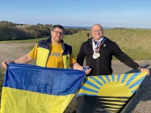 Пауерліфтер Данило Ковальов та його тренер Олексій Бичков тримають прапори України та Донецької області