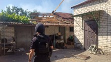 Правоохоронець дивиться на зруйновану будівлю.