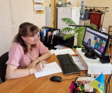 Представник військової адміністрації сидить за столом та слухає доповідача на семінарі