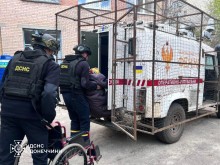 Рятувальники групи "Фенікс" вантажать маломобільну жінку на евакомобіль, поруч її крісло колісне