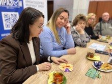 Жінки сидять за столом та грають у гру про Донеччину