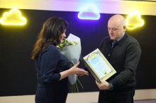 Юрій Вінокуров тримає почесну грамоту, яку вручає працівниці ЖКГ.