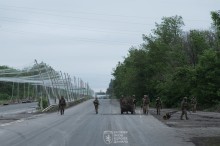 Військові йдуть до дорозі, накритої антидроновими сітками