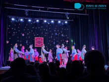 Хореографічний колектив виконує танець на сцені. Хлопці та дівчата у національних костюмах.