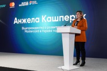 Анжела Кашперук, віцепрезидентка з розвитку бізнесу Mastercard в Україні та Молдові, на форумі, стоїть на сцені та розповідає.
