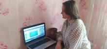 Учасниця вебінару єдності та взаємодії, яка уважно дивиться в екран монітора.