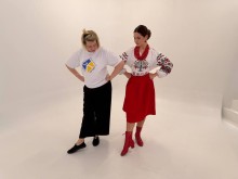 Фахівець центру культури показує моделі у вишиванці позу для фото