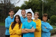 Діти в жовтих та блакитних худі стоять у таборі під час відпочинку