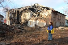 Фоторобота учасниці конкурсу. У центрі композиції дівчина з українським прапором на спині на фоні зруйнованої війною будівлі.