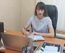 Представник військової адміністрації сидить за столом та слухає доповідача на семінарі