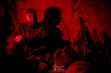 Ніч. Військовий в окопі, поруч зброя.