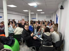 Учасники творчого змагання «Мовні перегони» сидять за столами в світлому укритті