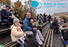 Глядачі на заході чидять на лавках