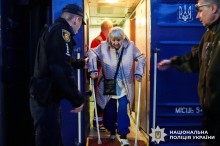 Представники служб допомагають жінці на милицях вийти з потяга