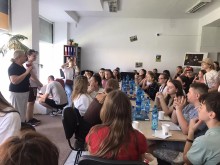 Діти Сіверської громади та діти Оноківської громади у Словаччині. Сидять за столом, на столі папір олівець та питна вода. Уважно слухають дорослу людину.