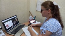Представник військової адміністрації сидить за столом та слухає доповідача на семінарі