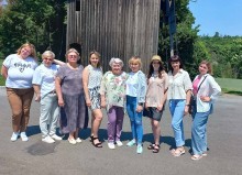Педагоги на фоні старовинного дерев’яного млина - одного з експонатів Національного музею народної архітектури та побуту України.