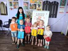 Групове фото дітей разом із фахівцем центру надання соціальних послуг та виготовленими поробками для татусів