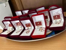 Пам’ятні подарунки для випускників Бахмутської громади: золоті кулони у формі серця та інших символів, упаковані в оксамитові футляри.