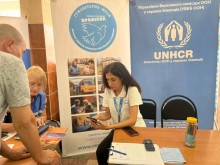 Жінки з благодійної організації допомагають оформити грошову допомогу, людині яка евакуювалась.