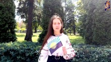 Дівчина у вишиванці тримає в руках прапор Донецької області