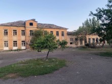 Двоповерховий будинок з вибитими вікнами після обстрілу.
