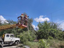 Автовишка та співробітники ДТЕК ремонтують електроопори.